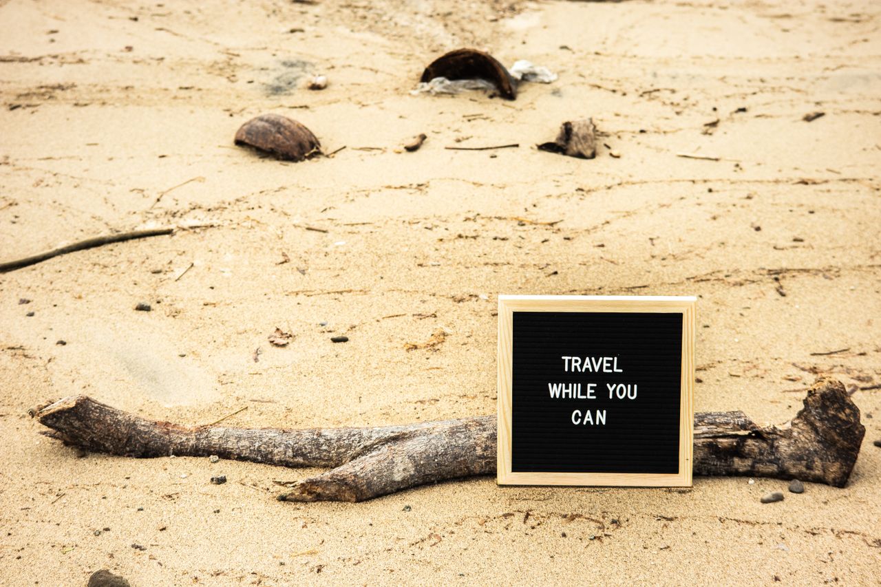 Offerings Motivational sign on sandy beach prompts travelers to seize the moment. Perfect for travel inspiration.